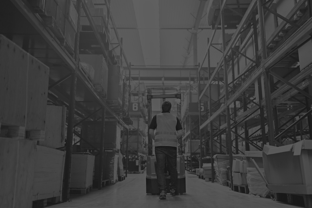 Storehouse employee in uniform working on forklift in modern automatic warehouse