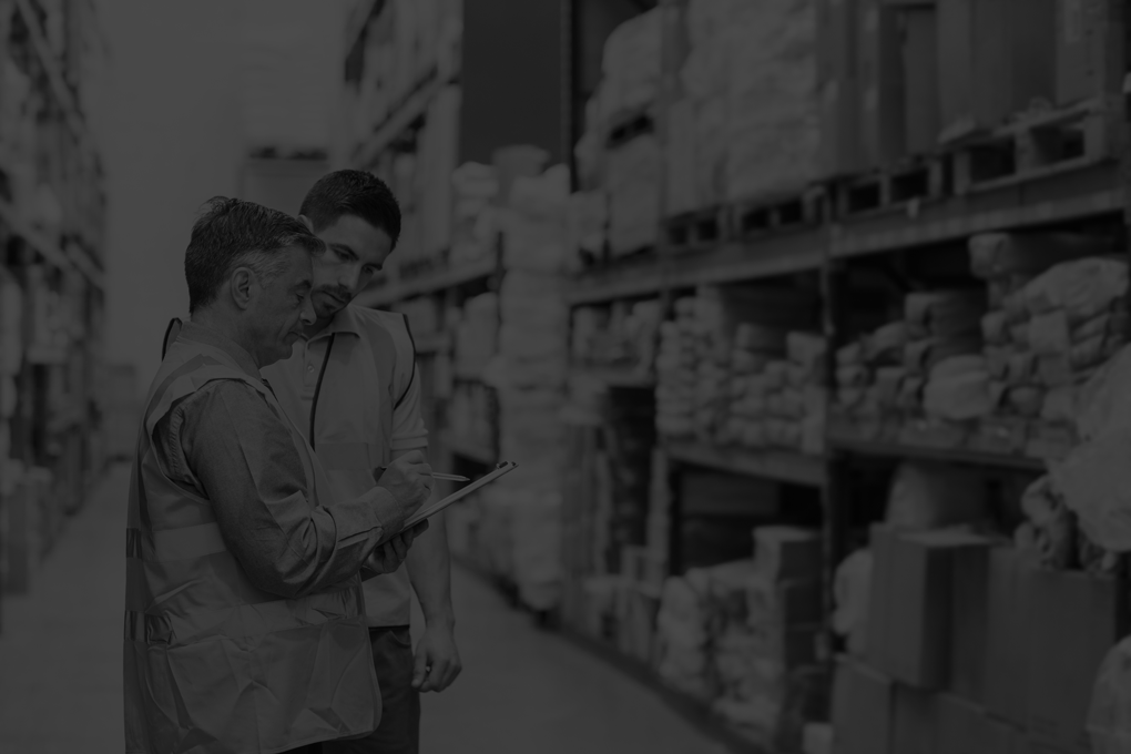 Warehouse workers talking together at work in a large warehouse