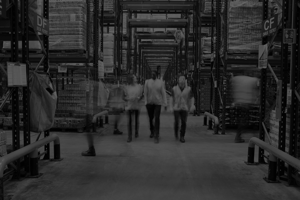 Staff in reflective vests walking to camera in a warehouse