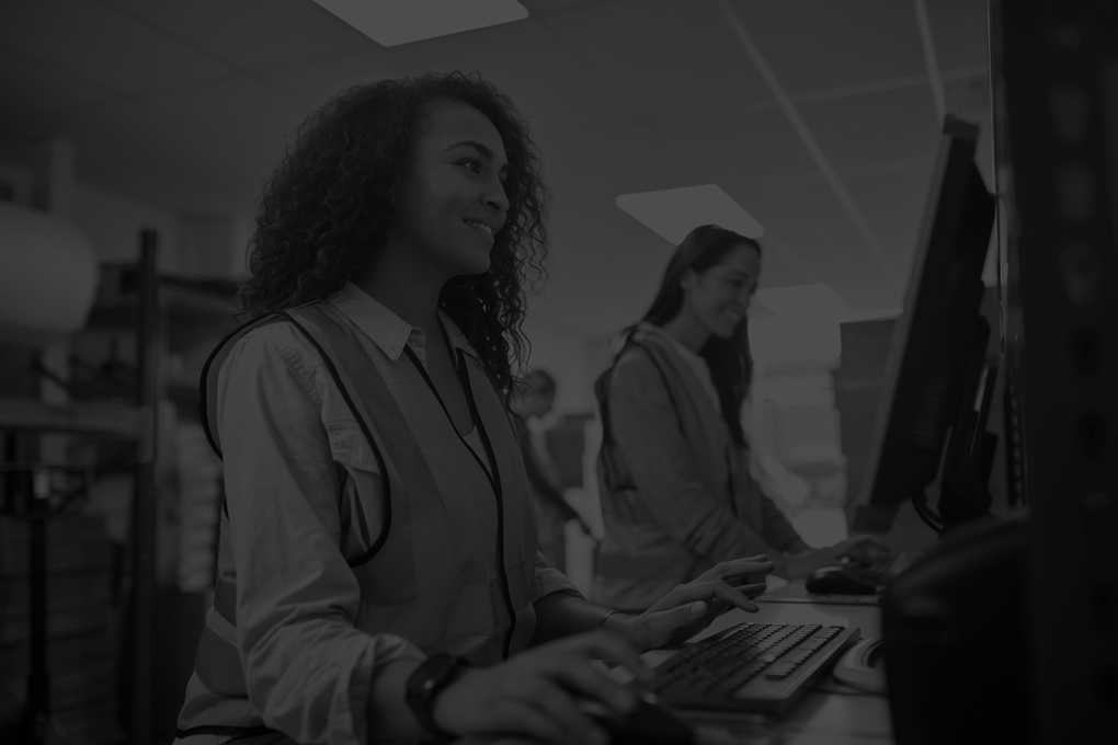 Female-Staff-In-Busy-Modern-Warehouse-Working-On-Computer-Terminals