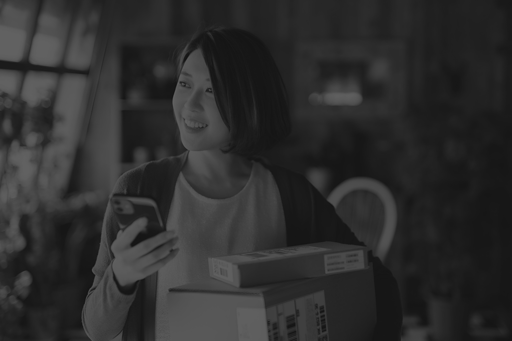 beautiful-smiling-young-asian-woman-with-smartphone-receiving-parcels-with-home-delivery-service-home-online-shopping-mobile-payment-enjoyable-shopping-experience