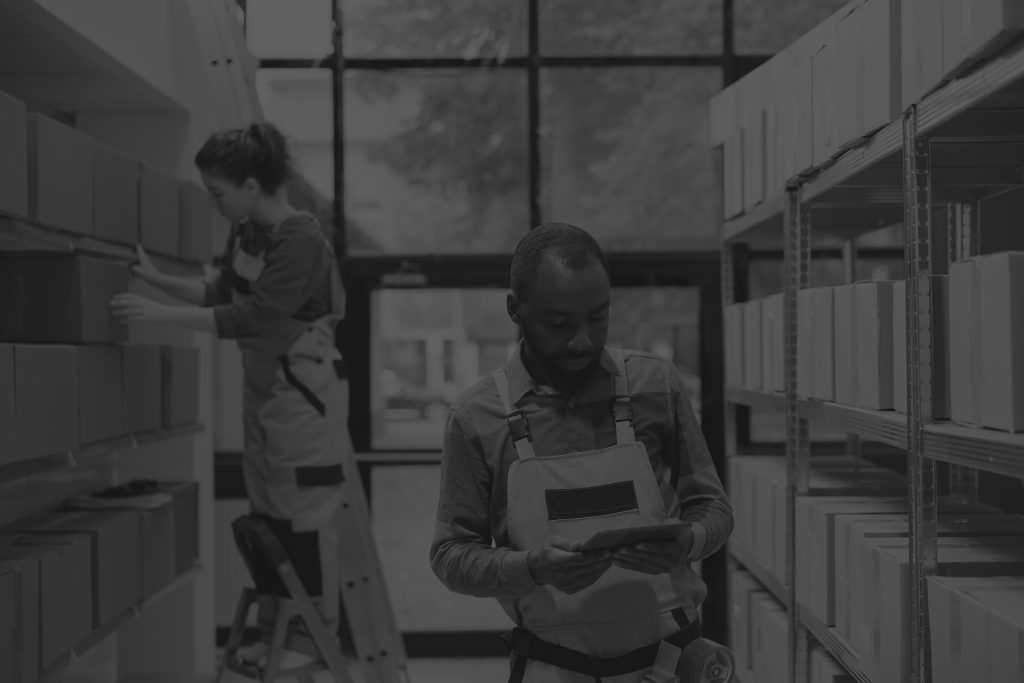 warehouse employee analysing merchandise checklist black and white