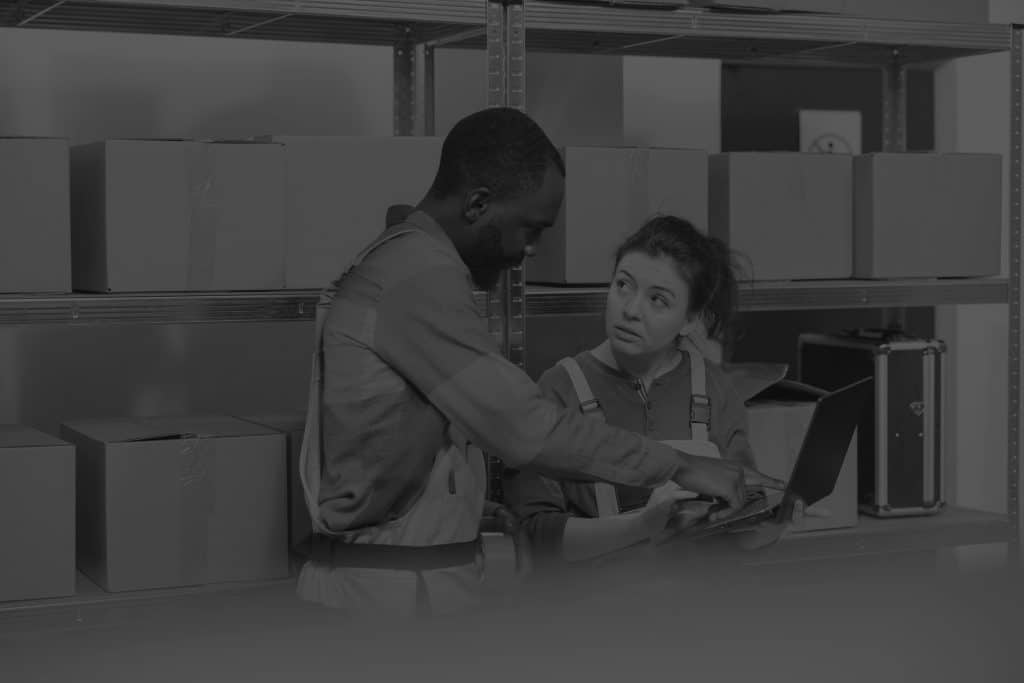 multi-ethnic-stockroom-supervisor-packing-parcels-wms-implementation-black-and-white