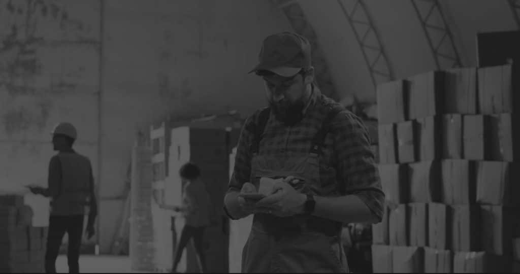 man in inefficient warehouse on mobile phone black and white