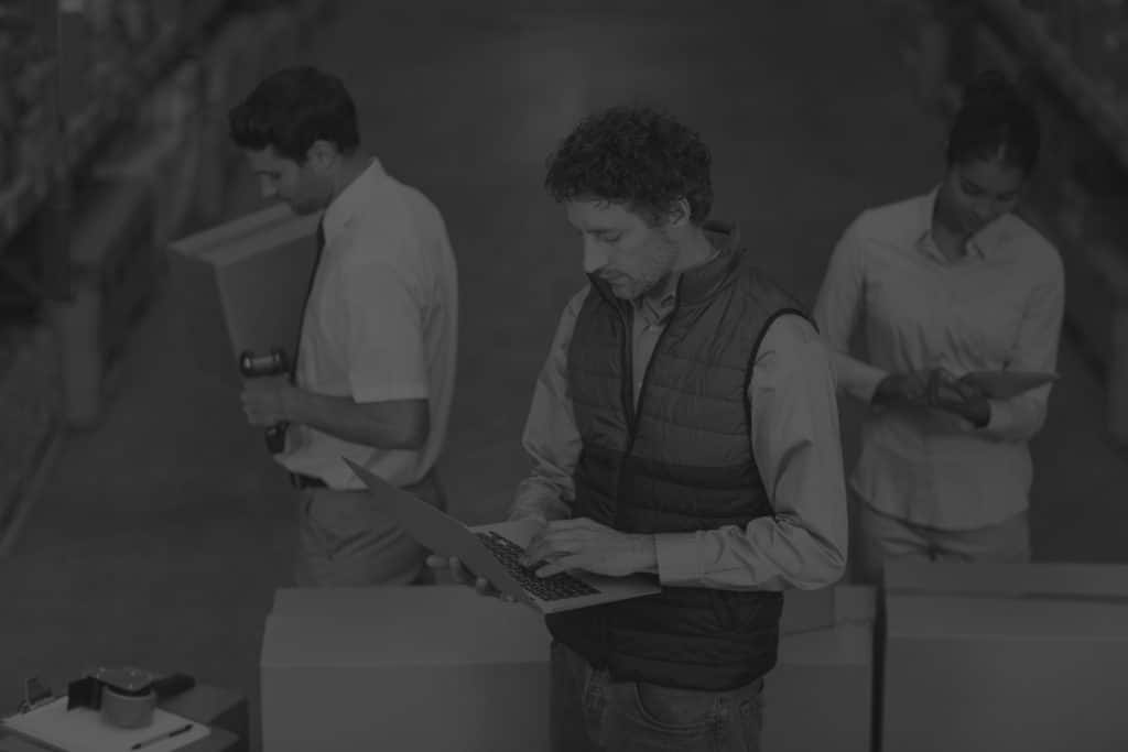 warehouse team with different technology preparing shipment in black and white