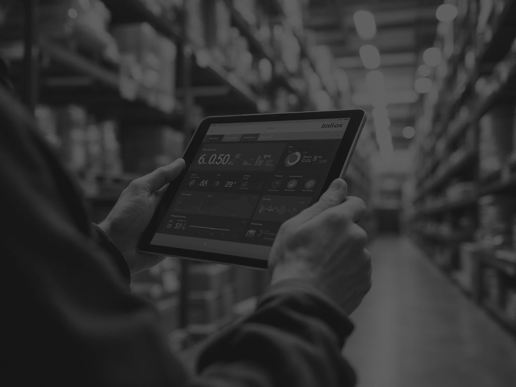 mans hands holding a tablet with warehouse data on
