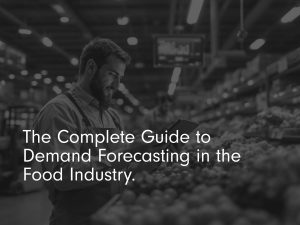 The complete guide to demand forecasting title image in black and white with man in warehouse looking at vegetables holding a tablet