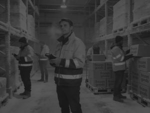 warehouse workers with hi vis jackets in cold chain warehouse black and white