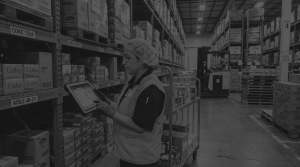 female worker using warehouse management system in food and beverage warehouse